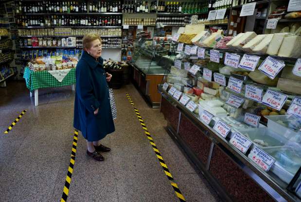Social distancing photo gallery - old woman shopping for food in Italy