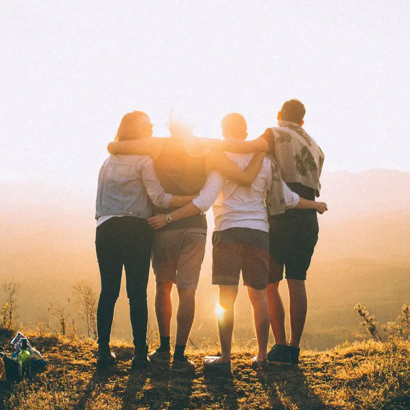 speak like a person - group of four people hugging at sunrise