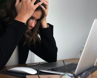 how stressful is a google search algorithm update - girl with hands in her head at a desk in front of a laptop