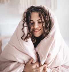self-compassion and digital marketing - dark haired girl wrapped in a blanket