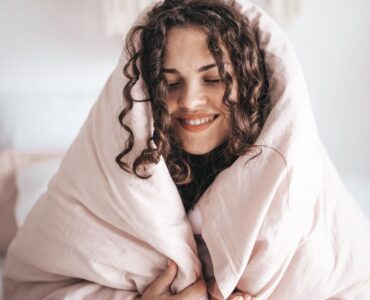 self-compassion and digital marketing - dark haired girl wrapped in a blanket