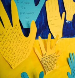 faqs for ukrainians - board with yellow and blue paper hands